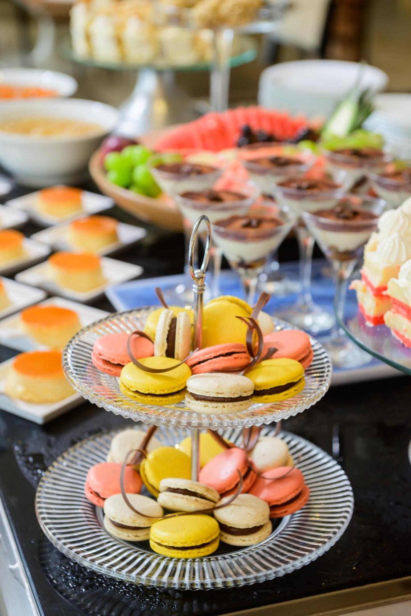 Hotel Luzeiros Fortaleza Exterior photo The photo displays an array of delightful desserts arranged on a table. In the foreground, there is a multi-tiered stand featuring colorful macarons in shades of yellow, pink, and white, some topped with chocolate. In the background, there are small 