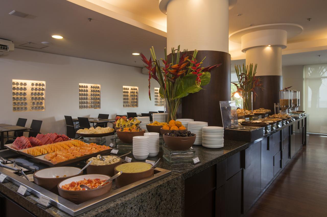 Hotel Luzeiros Fortaleza Exterior photo The photo displays a buffet setup in a dining area. On the counter, there are various dishes arranged attractively. You can see a colorful assortment of fruits and salads, including slices of watermelon and other fruits. There are also several bowls 